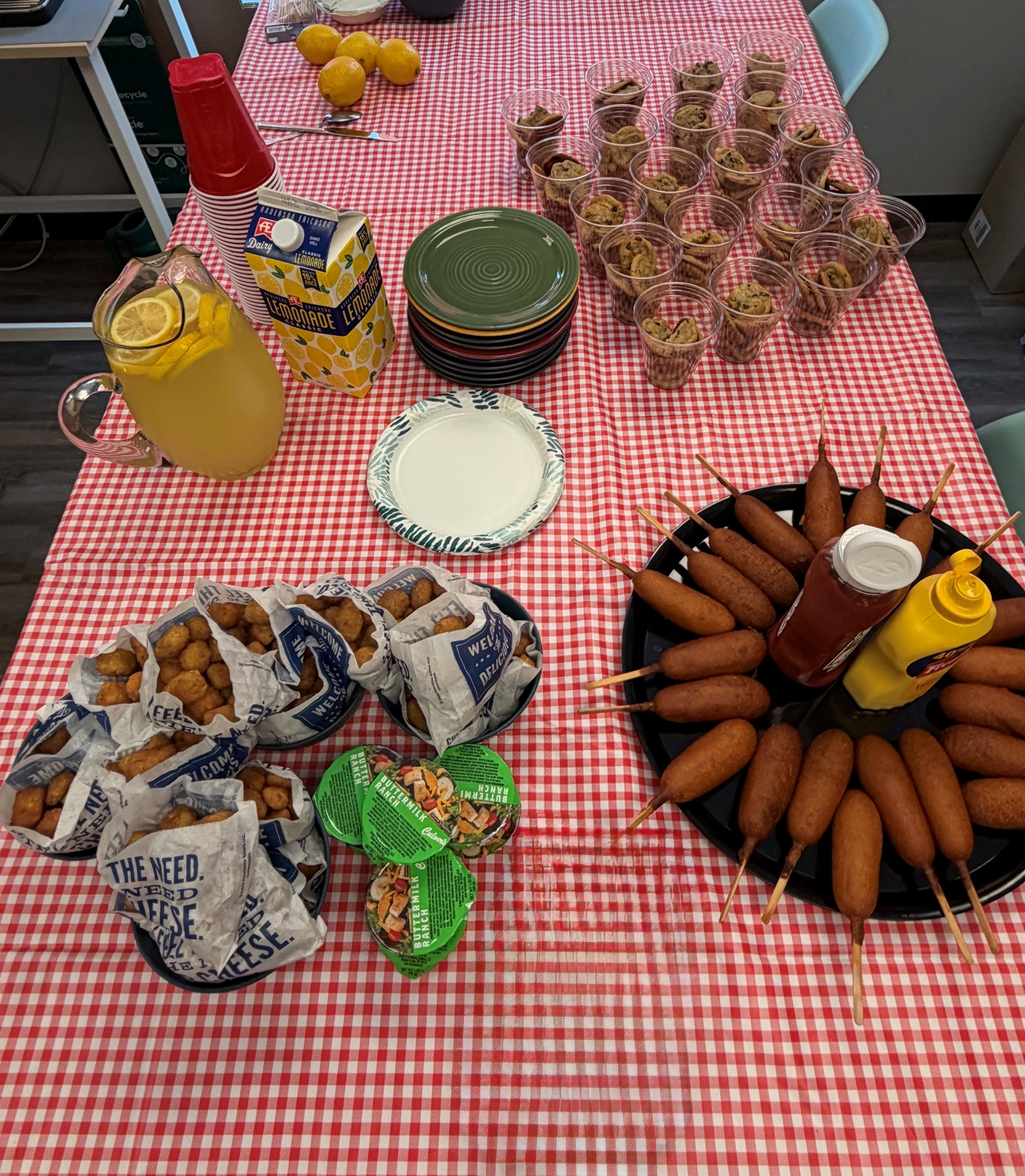 State fair-themed lunch spread with corn dogs, cheese curds, popcorn, and lemonade